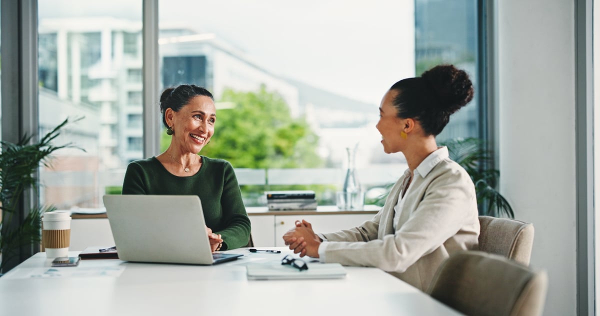 Two professionals meeting in an office to review employee benefits options